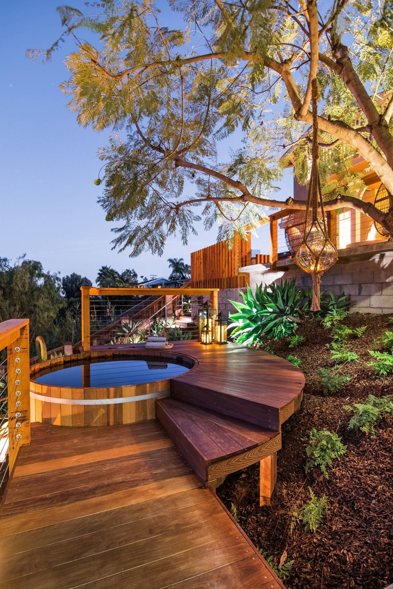 This picture shows the Cedar jacuzzi tub and surrounding Ipe deck lit at night. Photography: Brett Hilton