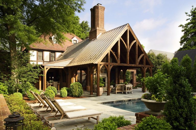 This porch and pool addition is both beautiful and functional. The design adds rustic charm with a timber frame structure and Tudor detailing that echoes the design of the existing home. Photo credit: Kip Dawkins
