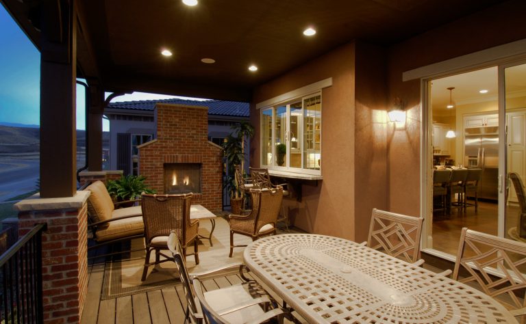 This rear, covered deck with a pass through bar from the kitchen is a great space to have a backyard party.