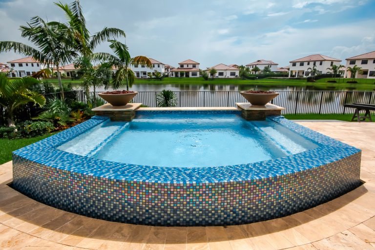 This swim spa with custom fire bowls and outdoor kitchen in Cooper City provides the perfect relaxing atmosphere.