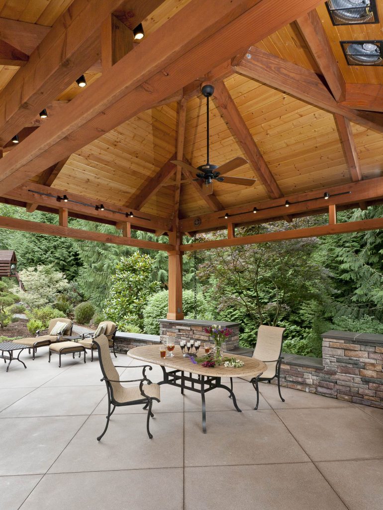 Timberframe with exposed cardecking over sanded concrete patio.