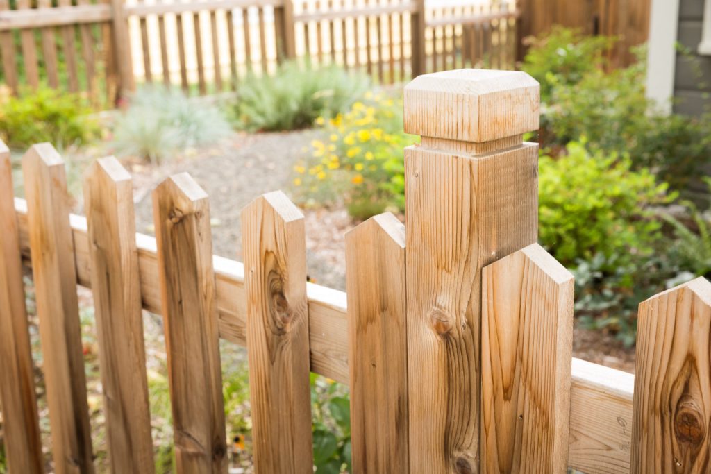 Traditional closed picket cedar fence w/ custom fence post + cap.