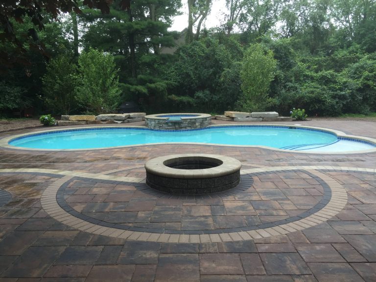 Transitional backyard brick and custom-shaped hot tub photo in Detroit