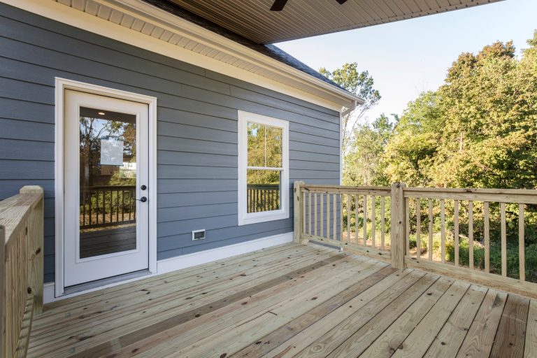 Transitional house with back porch. Staircase leads down to the backyard.