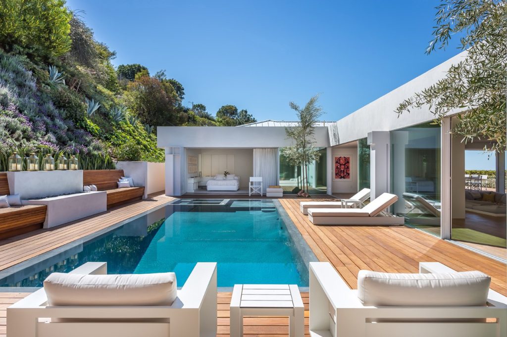 Trendy backyard rectangular infinity hot tub photo in Los Angeles with decking