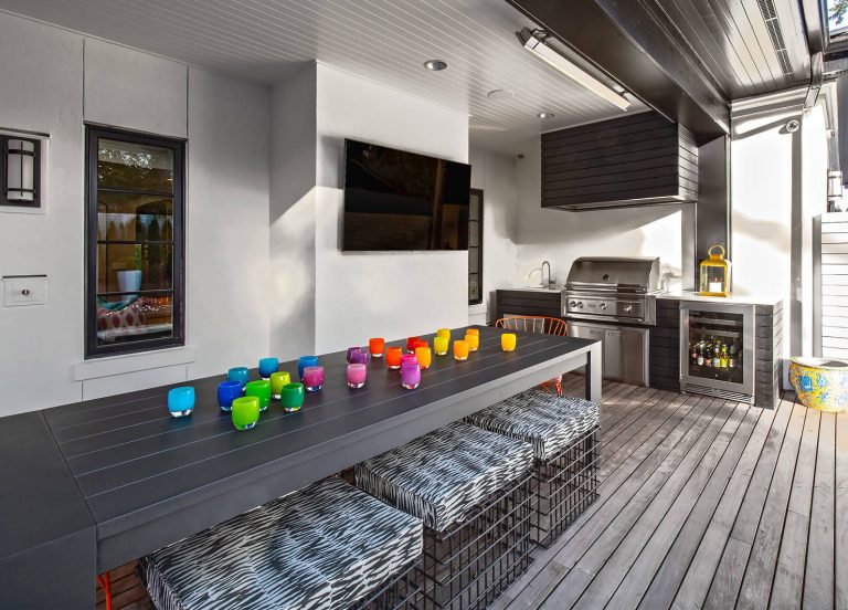 Trendy outdoor kitchen deck photo in Seattle with a roof extension