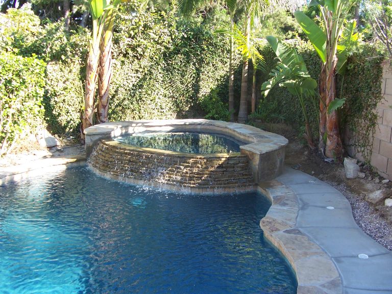 Tropical pool with a real fun raised spa allowing the water to flow into the rest of the pool. Fun place to be if you were in this pool don't you think....