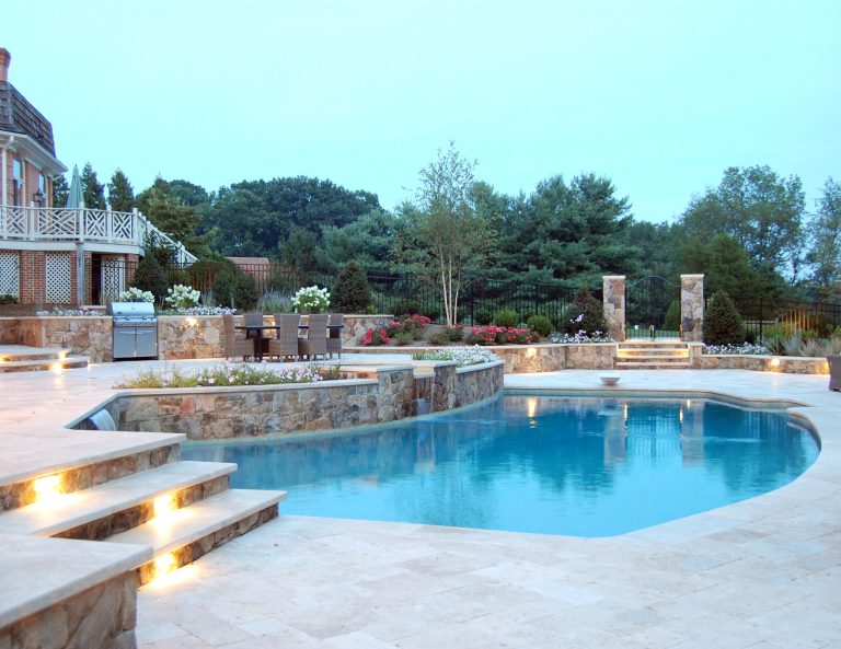 Tumbled travertine pool deck and step treads with bullnosed tumbled travertine pool coping.