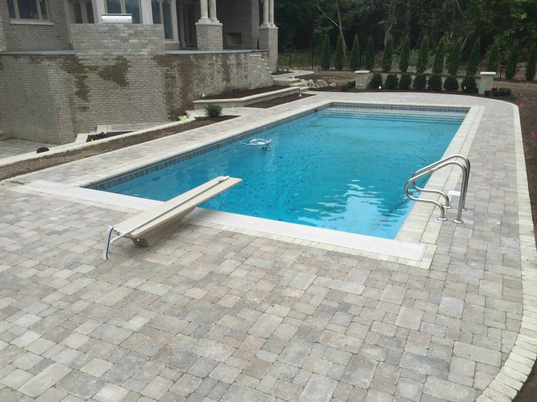 Tuscan backyard brick and custom-shaped hot tub photo in Detroit