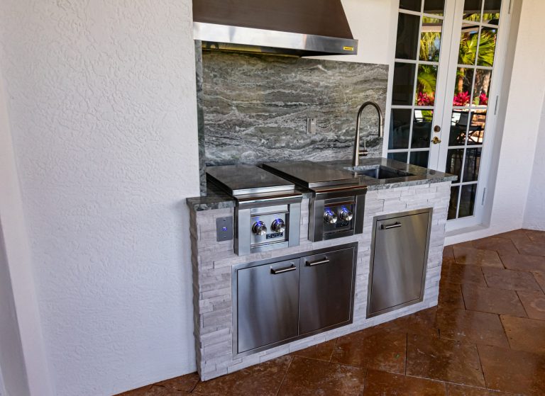 Tuscan backyard brick patio kitchen photo in Miami with a roof extension