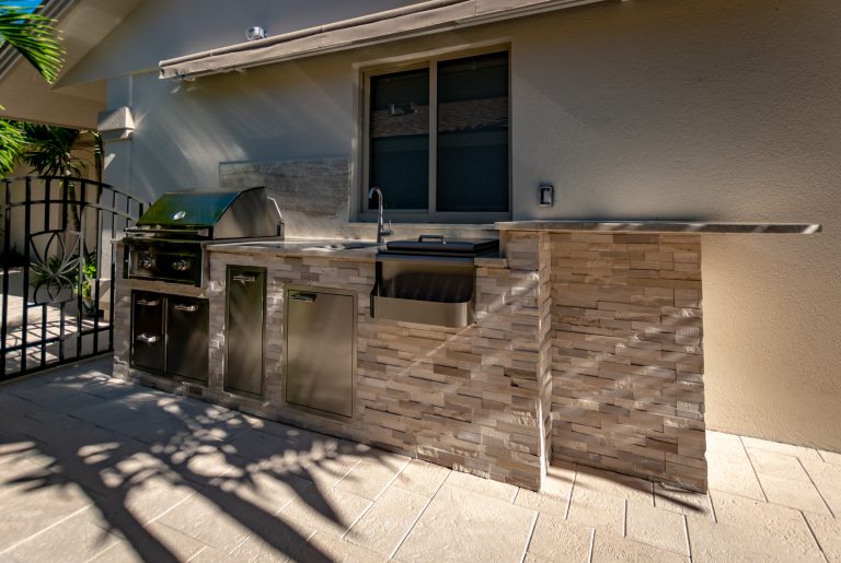Tuscan backyard brick patio kitchen photo in Miami with an awning