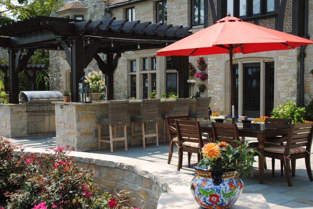 Tuscan patio kitchen photo in Milwaukee with a pergola