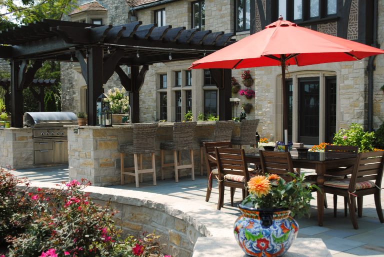 Tuscan patio kitchen photo in Milwaukee with a pergola