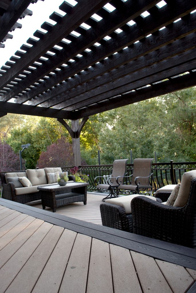 View from upper deck to the lower deck with tiered timber frame pergolas, ornamental metal railings and outdoor furniture. - Sarah Lee
