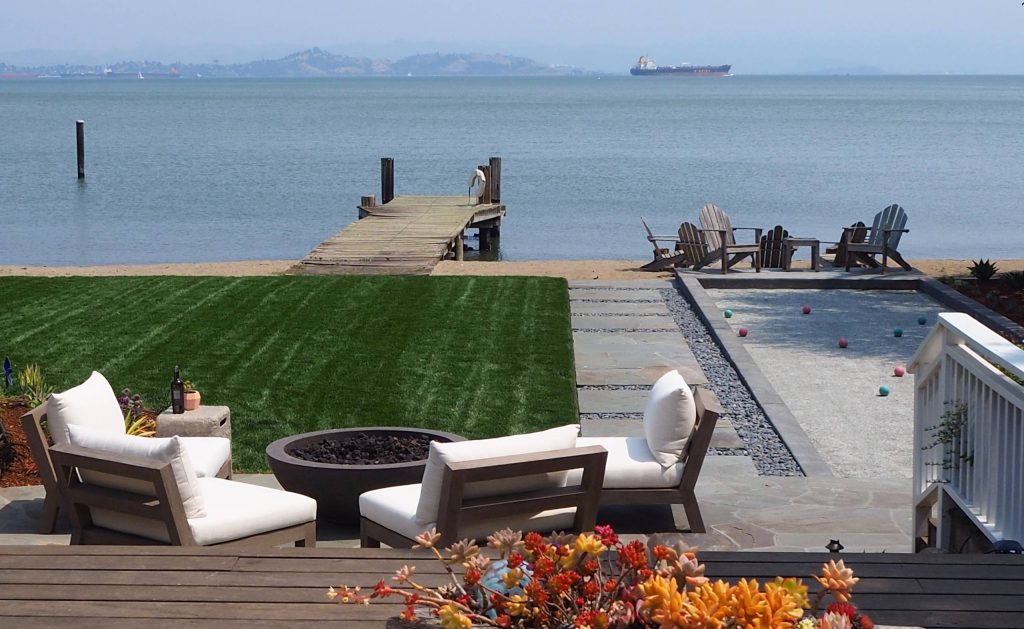 Views towards the bay across the bocce ball court , lawn and sitting area.