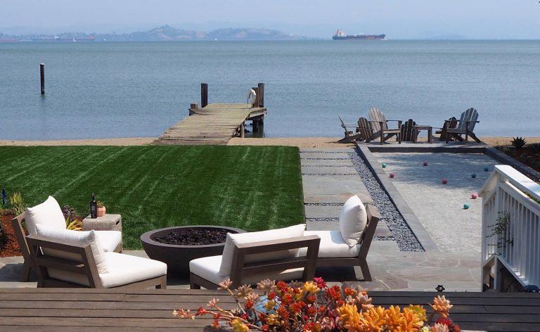 Views towards the bay across the bocce ball court , lawn and sitting area.