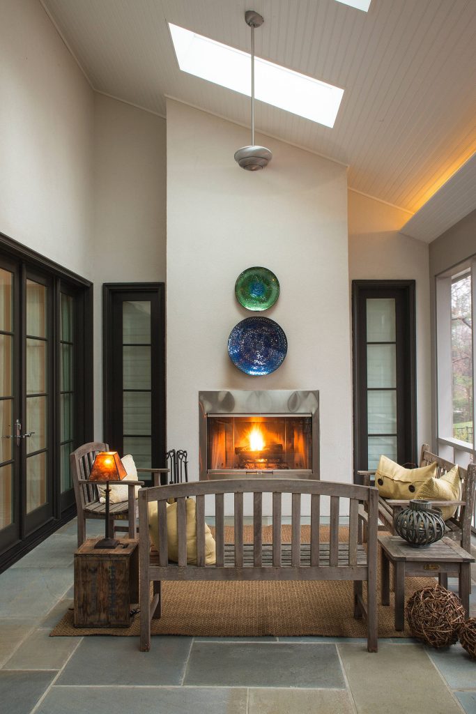 Warm and welcoming outdoor living space with screened wall, outdoor fireplace, blue slate tile, tall ceilings, outdoor ceiling fans, stucco exterior walls which all open to the interior great room. by Johker Design | Outdoor Photos | Porch | Landscaping | Landscape Design | Outdoor Living Space | Porch Design Ideas | Outdoor Living Space Ideas | Backyard Design