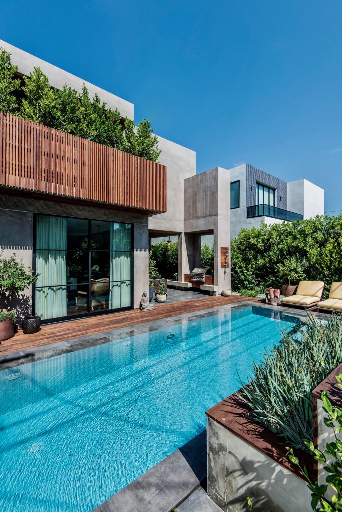 Warm gray stucco and wood alternate in the dynamic facade of this ground up residence