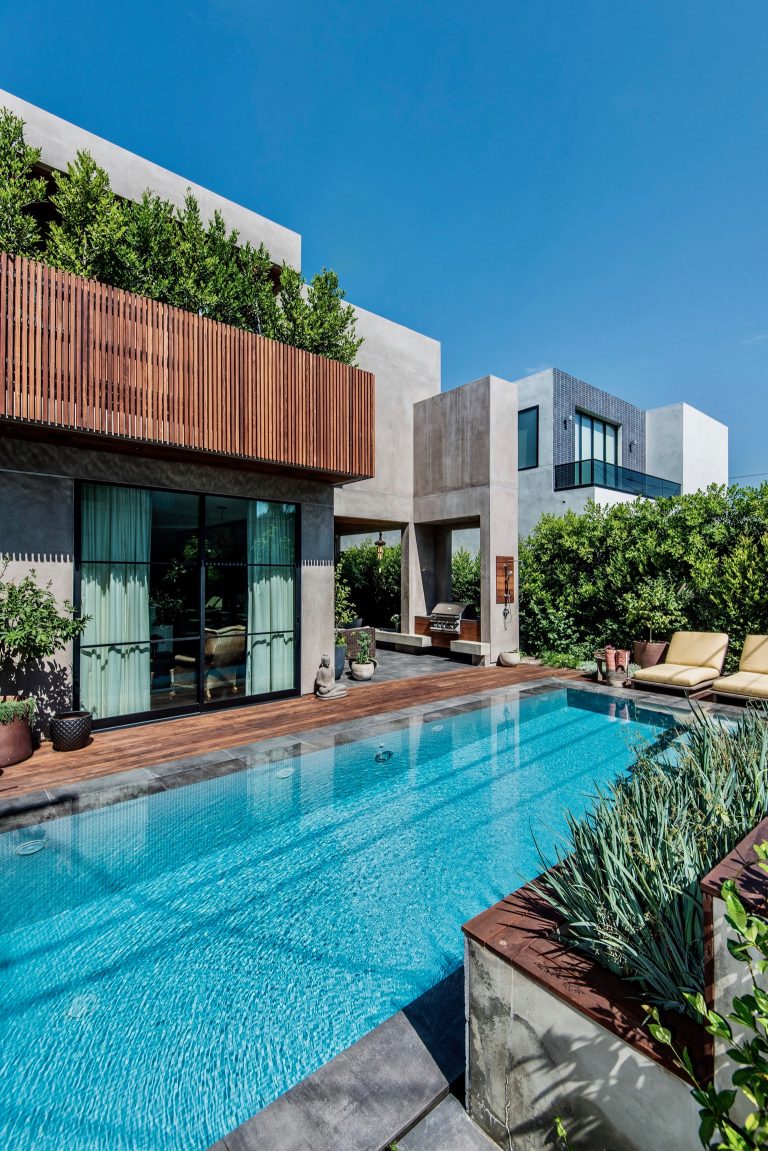 Warm gray stucco and wood alternate in the dynamic facade of this ground up residence