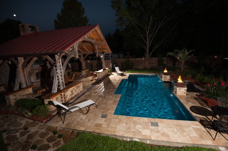 33' Elegance with Custom Tanning ledge and Copper Fire/Water Pots with travertine decking designed and installed by Cajun Pools & Spas Zoom Photography
