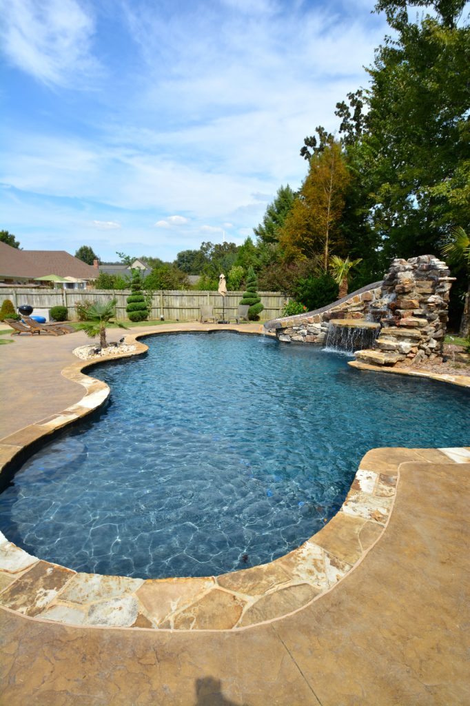 Water slide - mid-sized rustic backyard custom-shaped and stone lap water slide idea in Little Rock