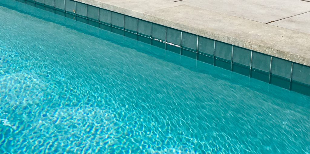 Waterline tile with iridescent accents highlight elegance with a unique twist.