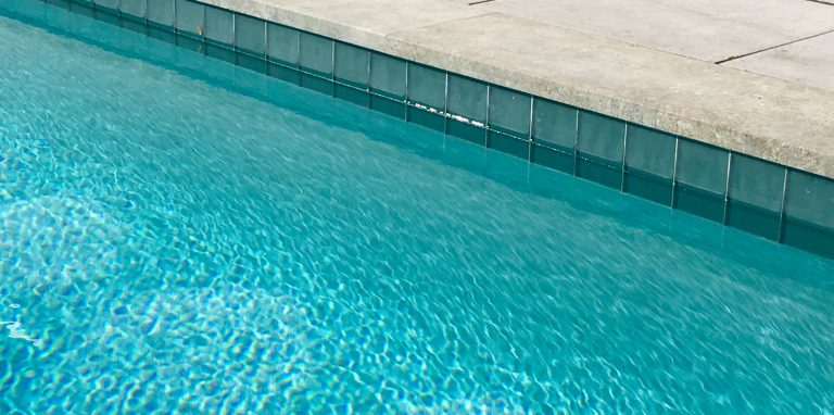 Waterline tile with iridescent accents highlight elegance with a unique twist.
