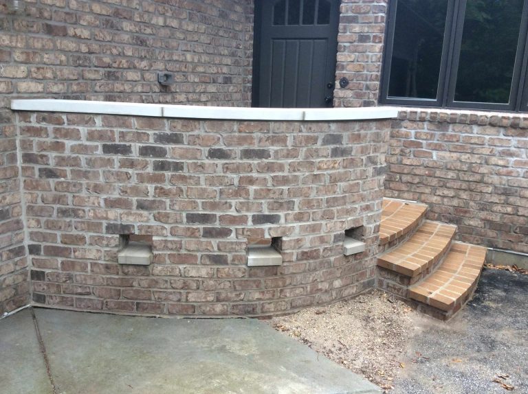 We surrounded this porch with a curved brick wall with a decorative water weep. The porch and steps were covered with a brick paver.