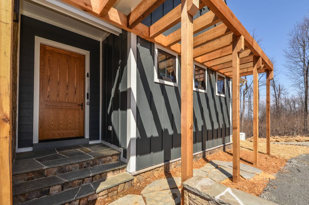 Wide Front Door on farmhouse exterior with flagstone path and steps.