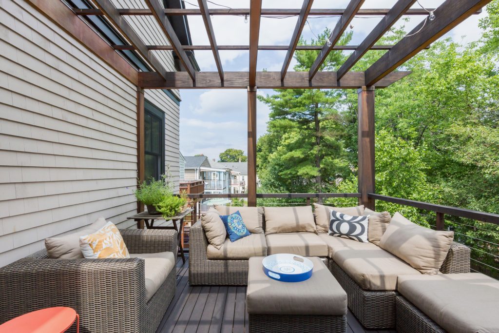 a modern deck off of a traditional shingle style home