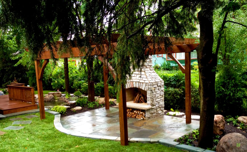 Mid-sized transitional backyard stone patio photo in Chicago with a fire pit and a pergola