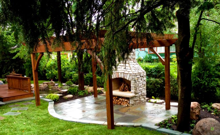 Mid-sized transitional backyard stone patio photo in Chicago with a fire pit and a pergola