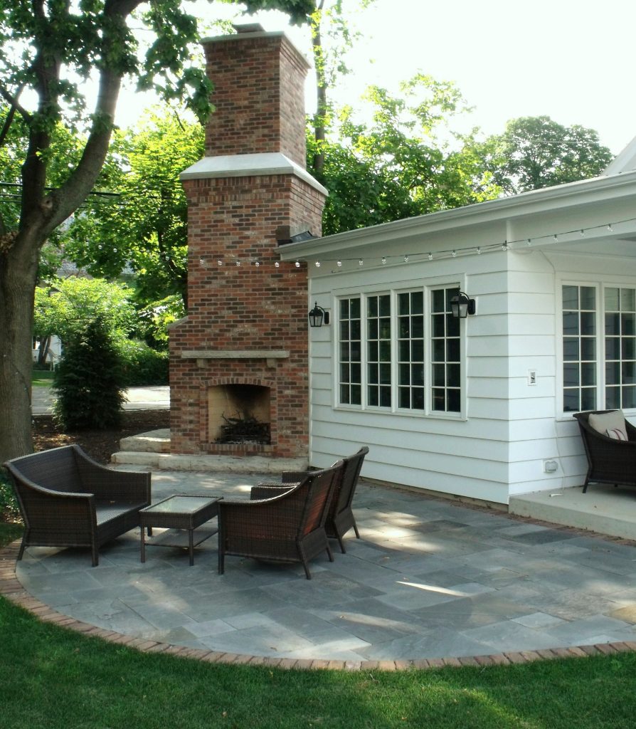 Example of a mid-sized classic backyard stone patio design in Chicago with a fire pit and no cover