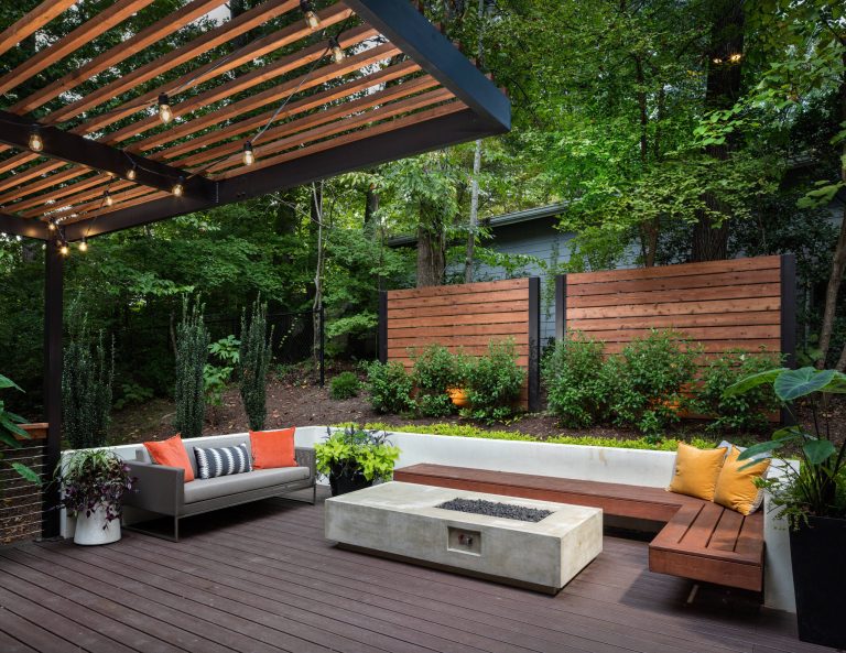 The upper level of this gorgeous Trex deck is the central entertaining and dining space and includes a beautiful concrete fire table and a custom cedar bench that floats over the deck. Light brown custom cedar screen walls provide privacy along the landscaped terrace and compliment the warm hues of the decking. Clean, modern light fixtures are also present in the deck steps, along the deck perimeter, and throughout the landscape making the space well-defined in the evening as well as the daytime.