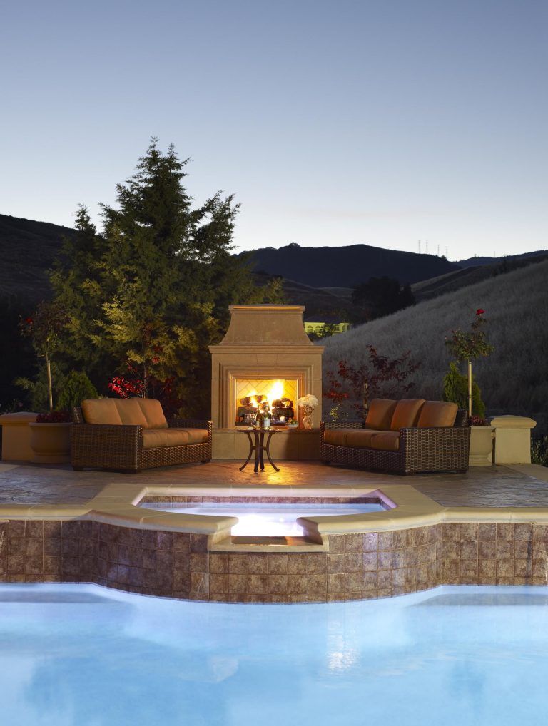The outdoor fireplace and raised spa, make a beautiful focal point in this exquisite backyard landscape renovation.