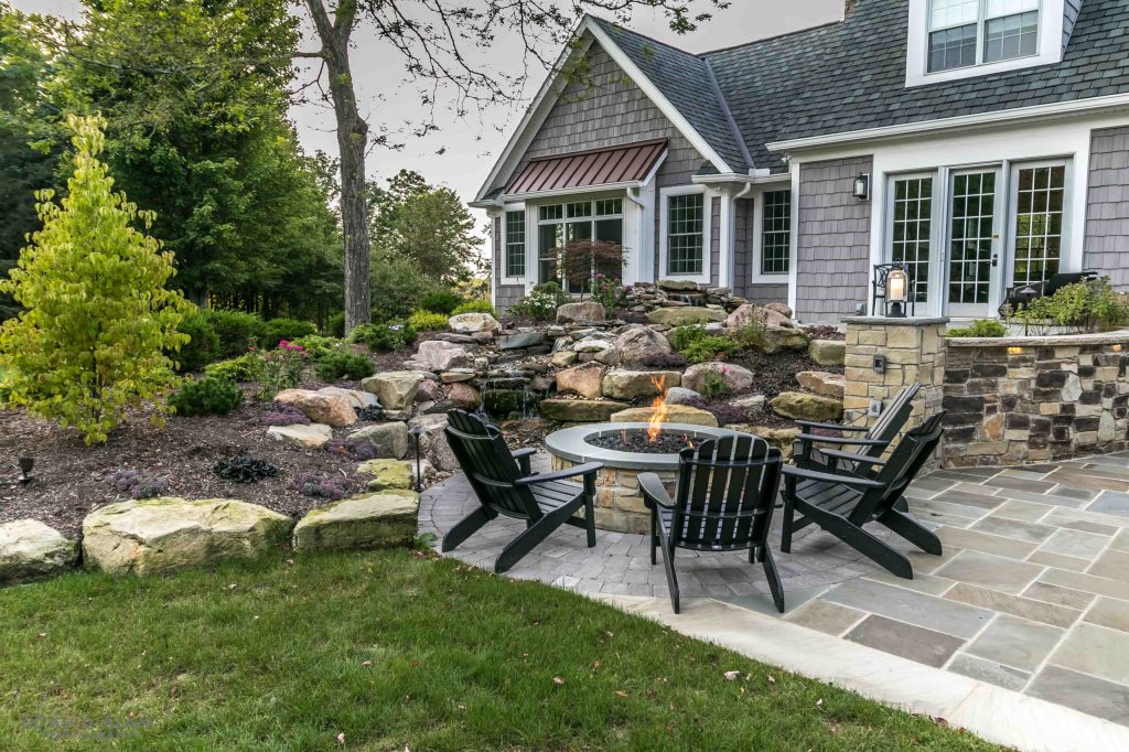 Patio - mid-sized traditional backyard stone patio idea in Cleveland with a fire pit and no cover