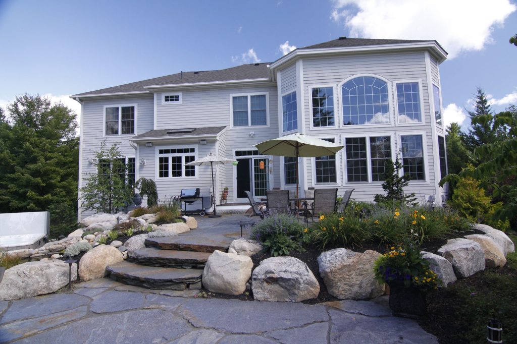 Inspiration for a large timeless backyard stone patio remodel in Boston with a fire pit and no cover