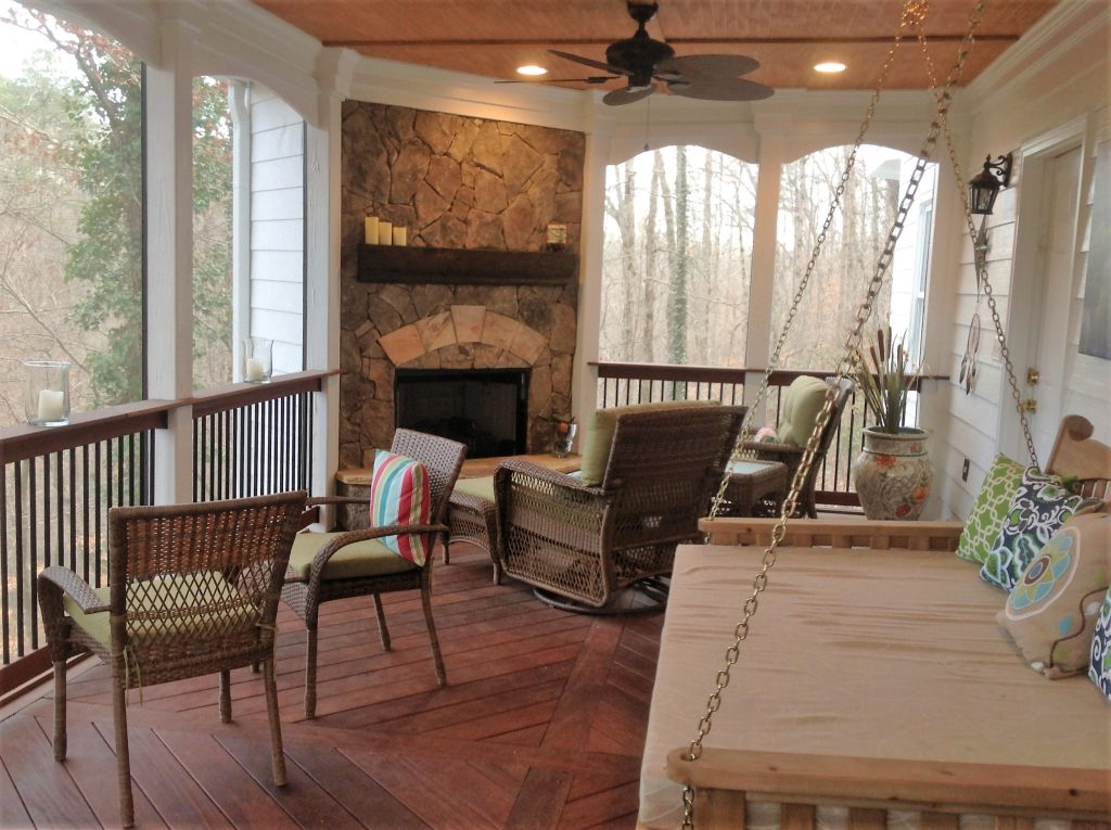 Our clients wanted a double decker covered back porch and open deck with dual fireplaces. The deck was made with rich dark wood, set off by white trim and a natural stone fireplace. The porch swing even converts into a bed!