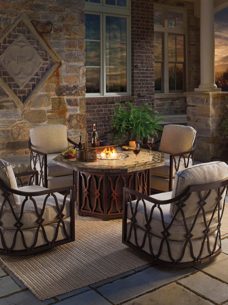 A cozy seating area is created by surrounding a stone top fire pit with several swivel rocker chairs. Natural tones like slate, gray, beige and umber give the space an elegant feel. Tommy Bahama Outdoor swivel rockers completes the look. by Tommy Bahama Home | Fire Pits|Backyard Design|Outdoor Living Spaces|Landscape Design|Backyard Ideas|Landscaping|Landscaping Ideas|Landscape Installation|Fire Feautures|Fire Pit
