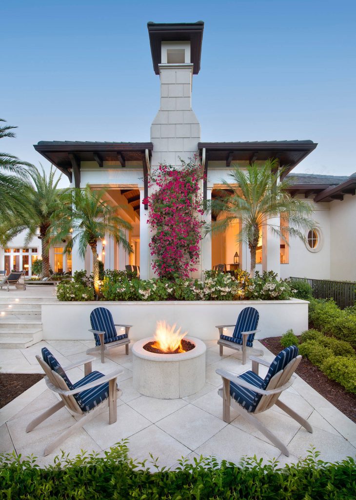Inspiration for a large tropical backyard stone patio remodel in Miami with a fire pit and no cover