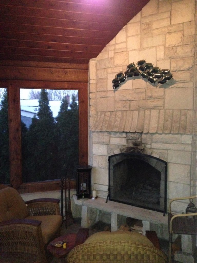 cathedral ceiling screened porch with all stone fireplace and mantle with wood cubbyhole storage