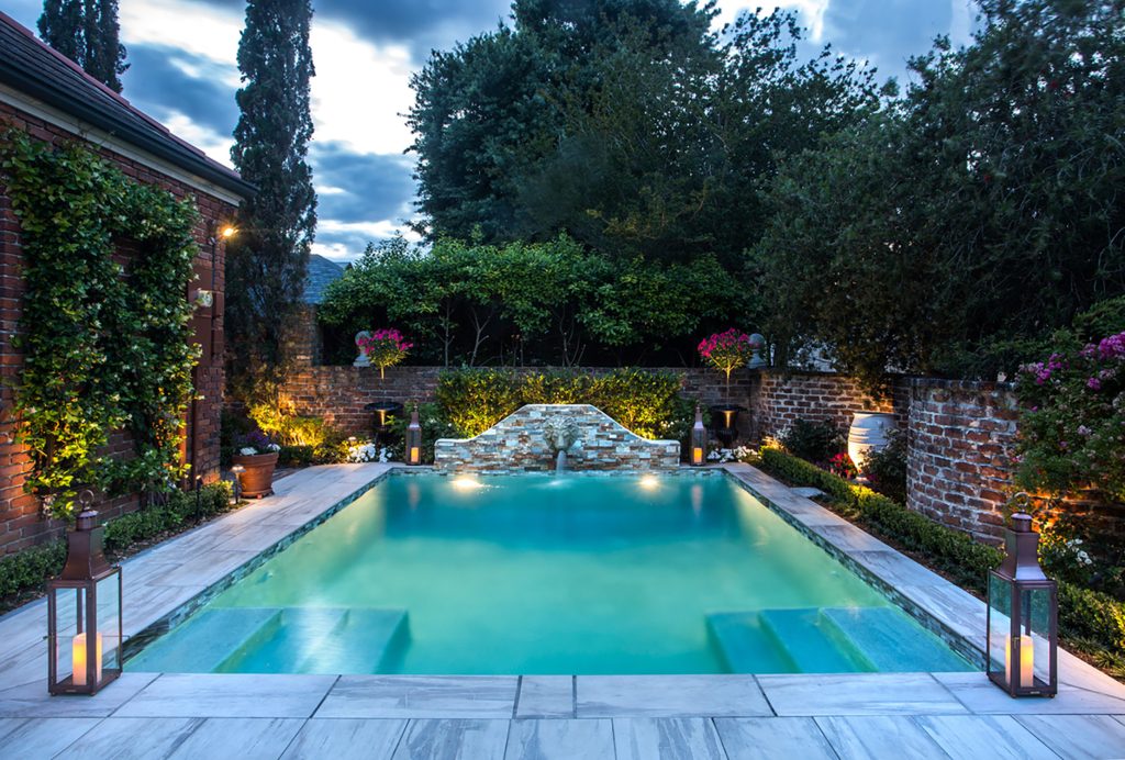 Bevolo Governor Pool House Lanterns add ambiance to this contemporary poolside oasis.