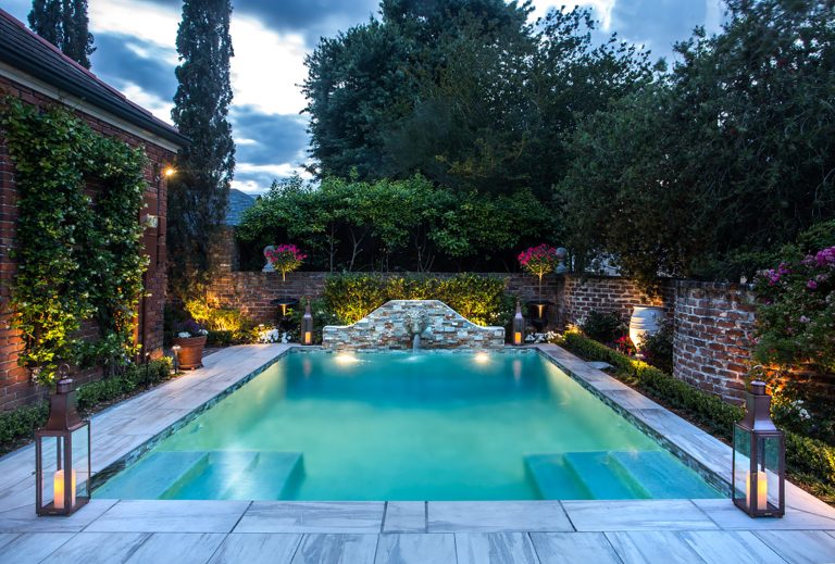 Bevolo Governor Pool House Lanterns add ambiance to this contemporary poolside oasis.
