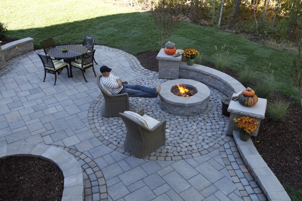Example of a large classic backyard concrete paver patio design in Richmond with a fire pit and no cover