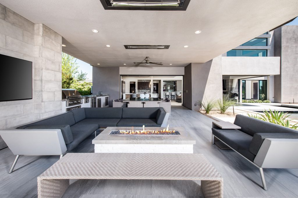 Inspiration for a large contemporary backyard patio remodel in Las Vegas with a fire pit and a roof extension