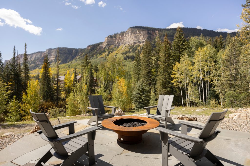 Evolved in the heart of the San Juan Mountains, this Colorado Contemporary home features a blend of materials to complement the surrounding landscape. This home triggered a blast into a quartz geode vein which inspired a classy chic style interior and clever use of exterior materials. These include flat rusted siding to bring out the copper veins, Cedar Creek Cascade thin stone veneer speaks to the surrounding cliffs, Stucco with a finish of Moondust, and rough cedar fine line shiplap for a natural yet minimal siding accent. Its dramatic yet tasteful interiors, of exposed raw structural steel, Calacatta Classique Quartz waterfall countertops, hexagon tile designs, gold trim accents all the way down to the gold tile grout, reflects the Chic Colorado while providing cozy and intimate spaces throughout.