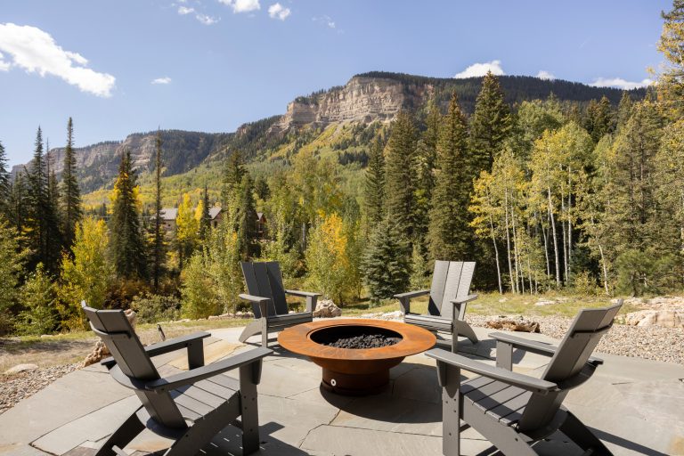 Evolved in the heart of the San Juan Mountains, this Colorado Contemporary home features a blend of materials to complement the surrounding landscape. This home triggered a blast into a quartz geode vein which inspired a classy chic style interior and clever use of exterior materials. These include flat rusted siding to bring out the copper veins, Cedar Creek Cascade thin stone veneer speaks to the surrounding cliffs, Stucco with a finish of Moondust, and rough cedar fine line shiplap for a natural yet minimal siding accent. Its dramatic yet tasteful interiors, of exposed raw structural steel, Calacatta Classique Quartz waterfall countertops, hexagon tile designs, gold trim accents all the way down to the gold tile grout, reflects the Chic Colorado while providing cozy and intimate spaces throughout.