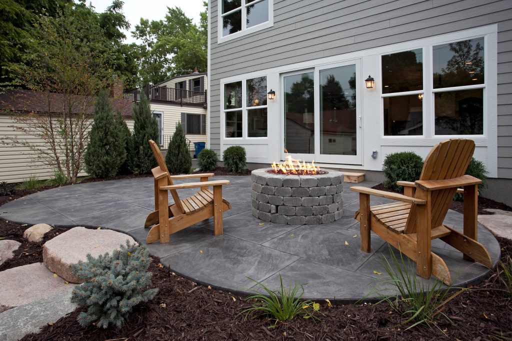 Inspiration for a large timeless stamped concrete patio remodel in Minneapolis with a fire pit and no cover