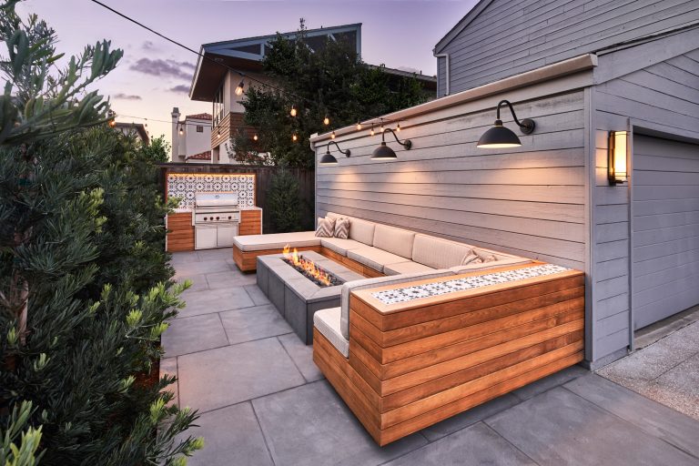 Bluestone Pavers, custom Teak Wood banquette with cement tile inlay, Bluestone firepit, custom outdoor kitchen with Teak Wood, concrete waterfall countertop with Teak surround.