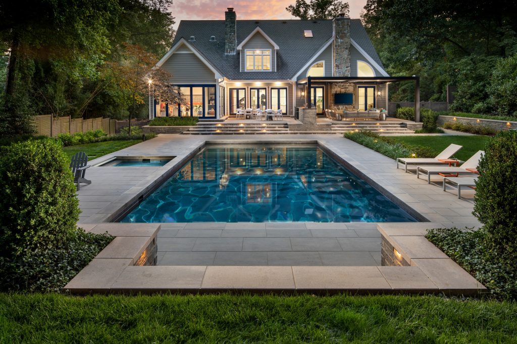 exterior landscaping twilight with pool, spa, and outdoor kitchen by Wheats Landscaping
